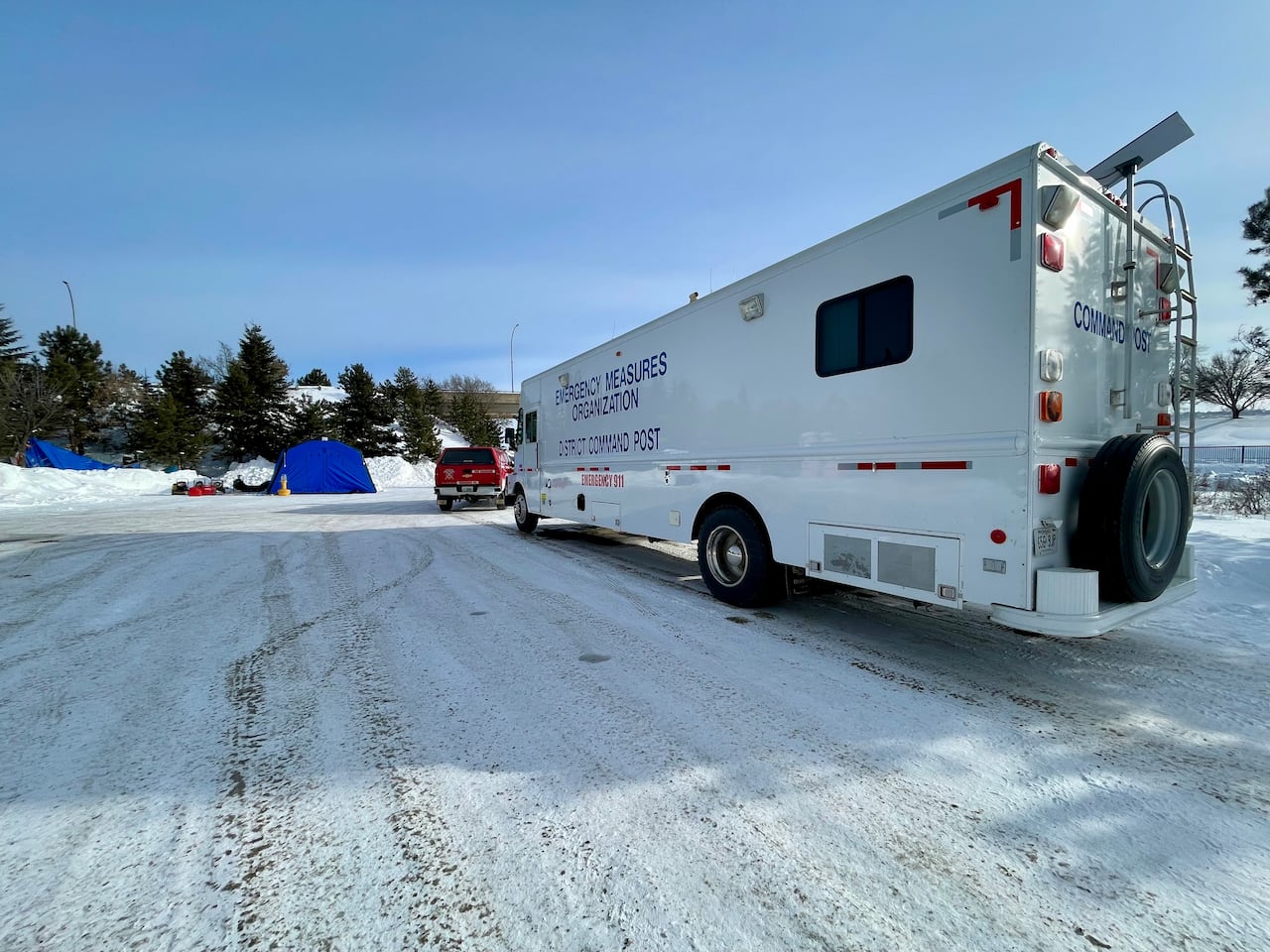 An emergency vehicle is seen parked in a snow-covered parking lot.