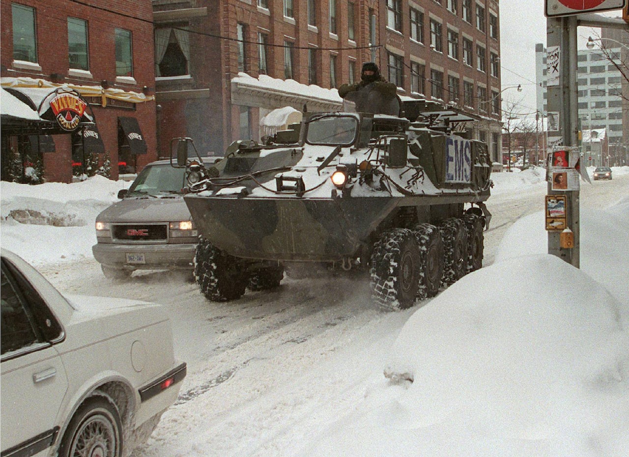 A military tanks is seen on a snowy city street