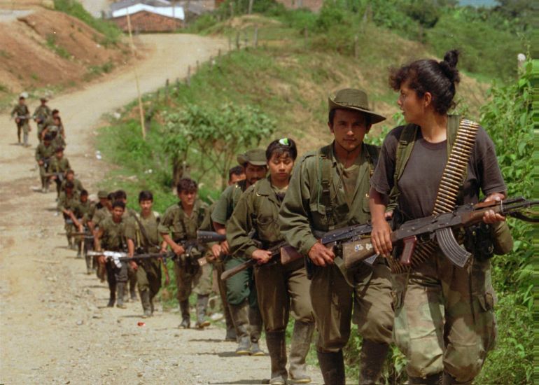 Rebels from the Revolutionary Armed Forces of Colombia (FARC), enter a small town near Miranda, Colombia, Wednesday, April 17, 1996. A column of the same rebel group ambushed a military convoy Monday killing 31 soldiers and wounding 18 outside the town of Puerres, located 350 miles southwest of Bogota. The FARC are the largest and oldest guerrilla group in Colombia. (AP Photo/Ricardo Mazalan)