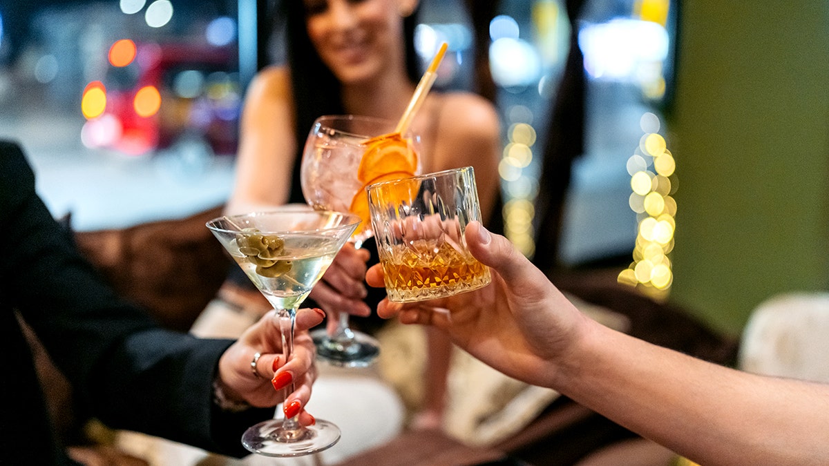 three friends cheers their cocktails