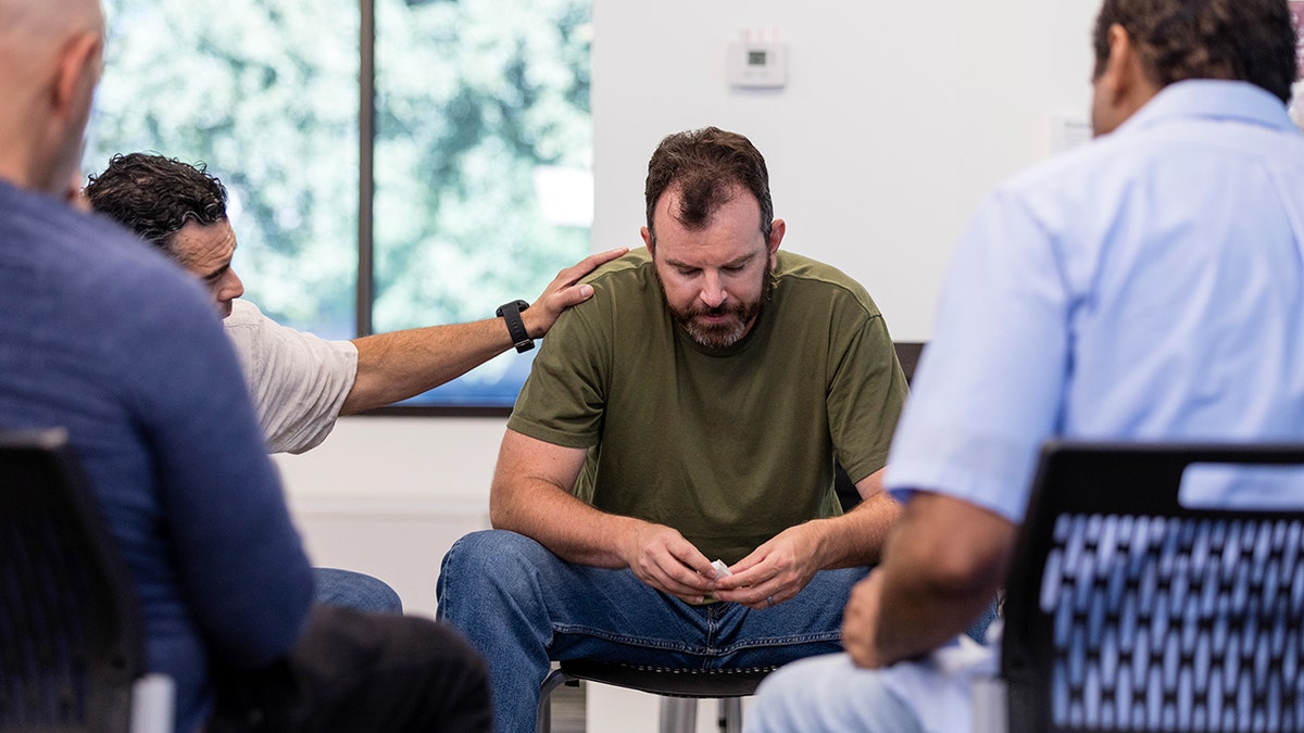 Therapist encourages emotionally distressed man.