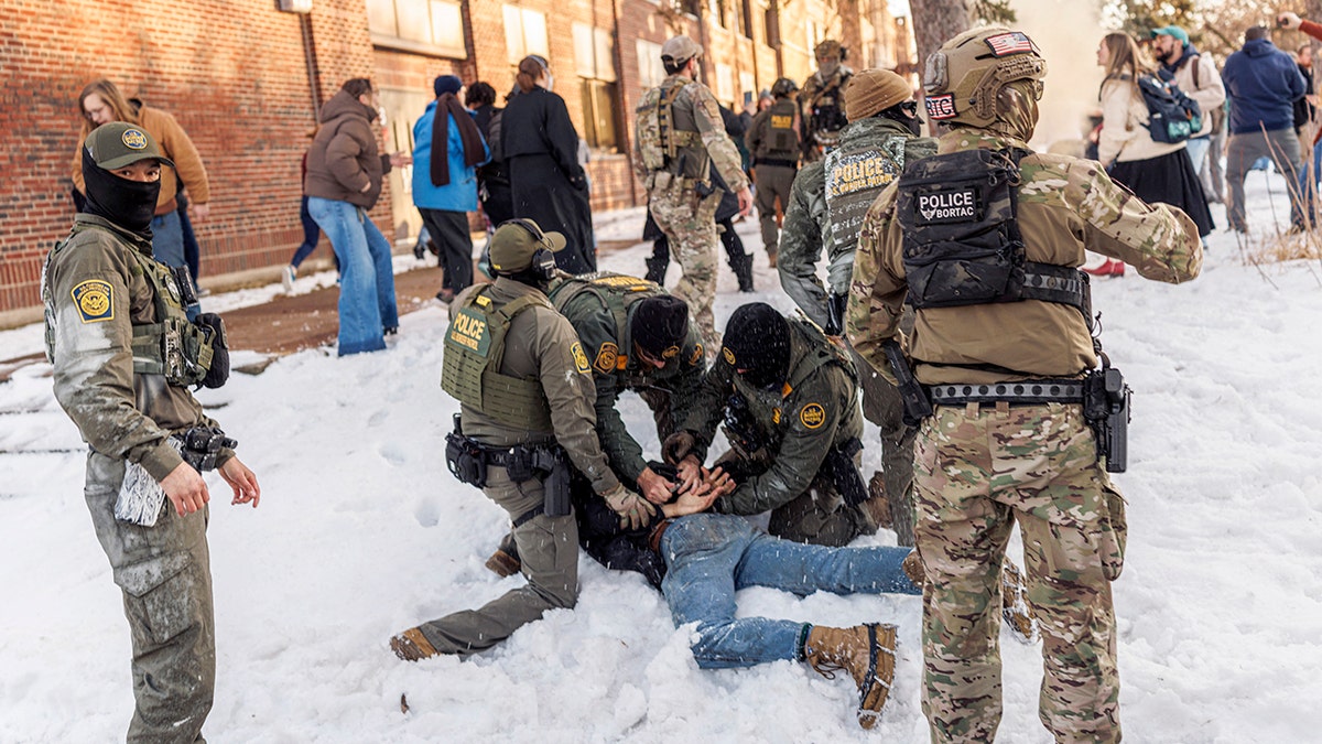 Federal immigration agents make an arrest outside a high school.