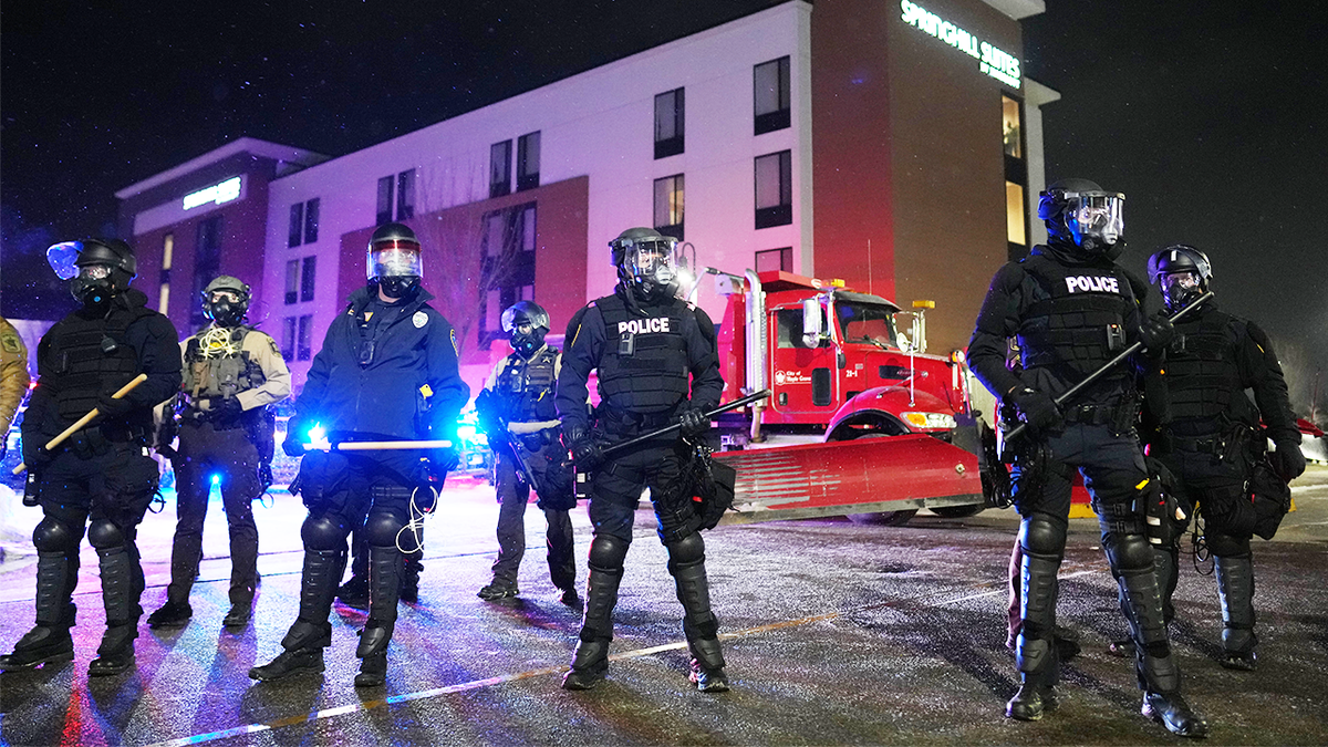 Law enforcement officers stand during a protest