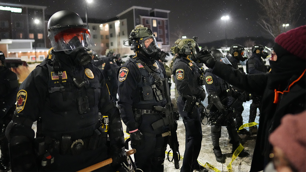 Maple Grove police officers stand during a protest