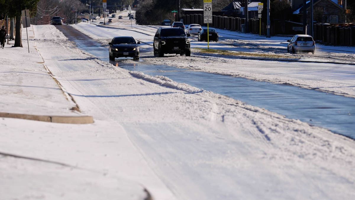 Cars travel along an icy road during a winter storm in Carrollton, Texas.