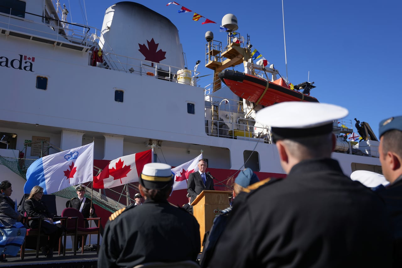 A man speaks to sailors from a ship.