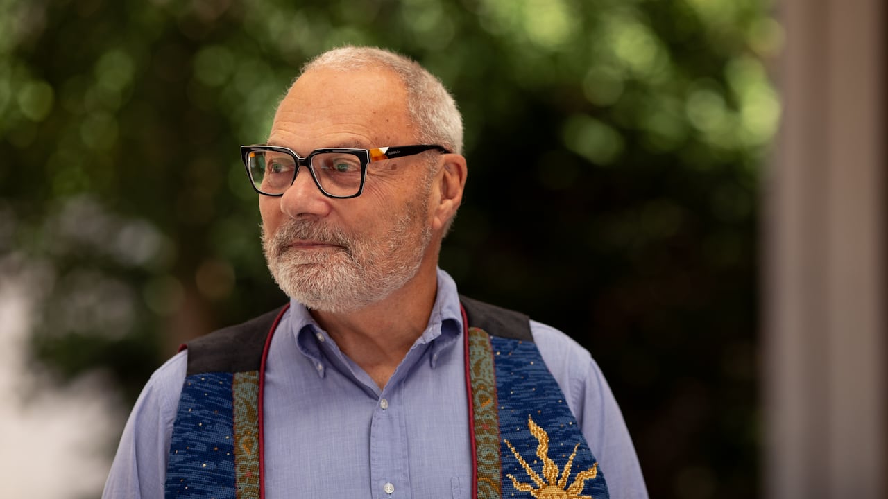 An older man in a vest.