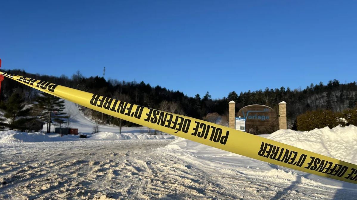 Police tape in front of a ski hill.