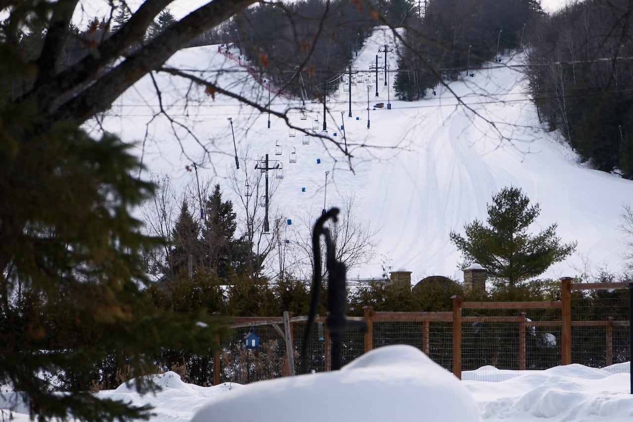 An empty ski hill is seen from a distance on a winter day.