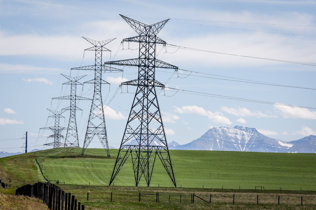 Power transmission lines are seen with the Rocky Mountains in the background near Pincher Creek, Alta., Thursday, June 6, 2024.