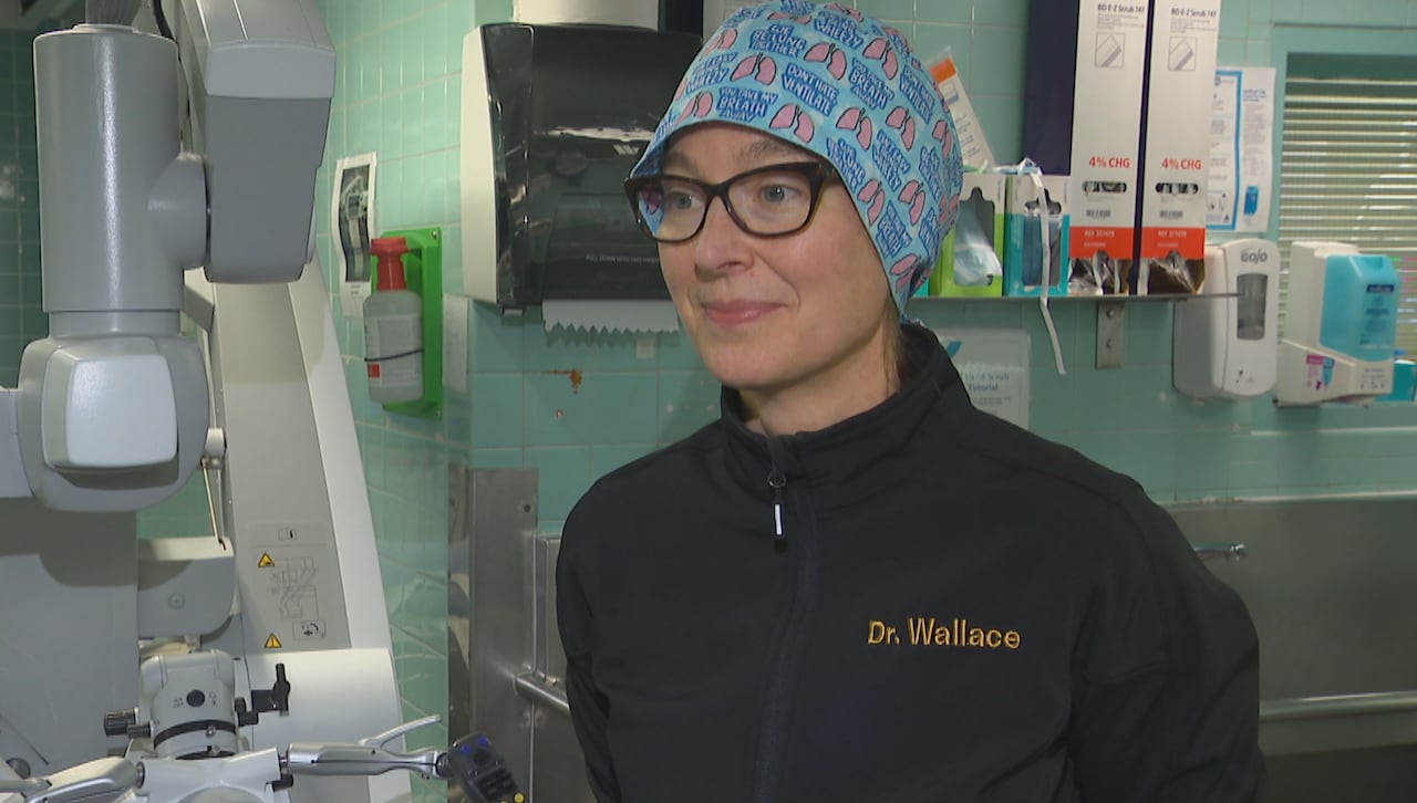 A surgeon stands outside an operating room.