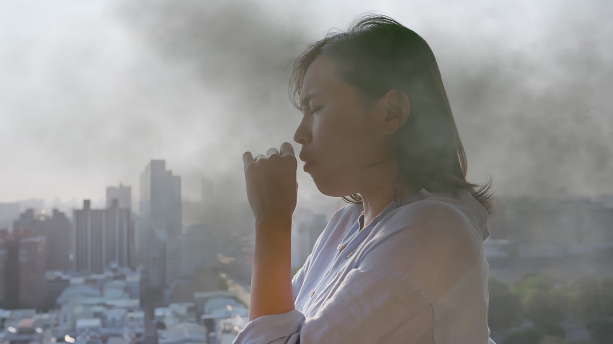 woman coughs in polluted air