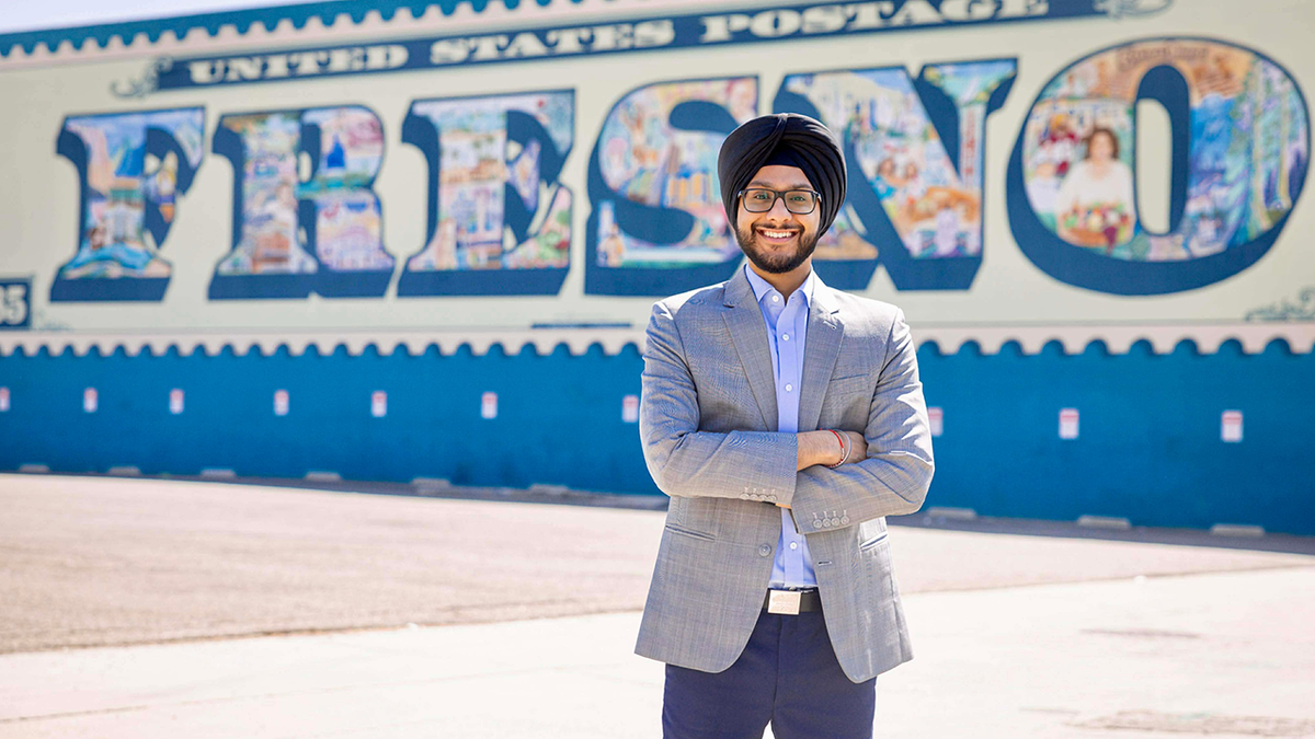 Nav Gurm, candidate for Fresno City Council District 7, stands in front of a Fresno mural