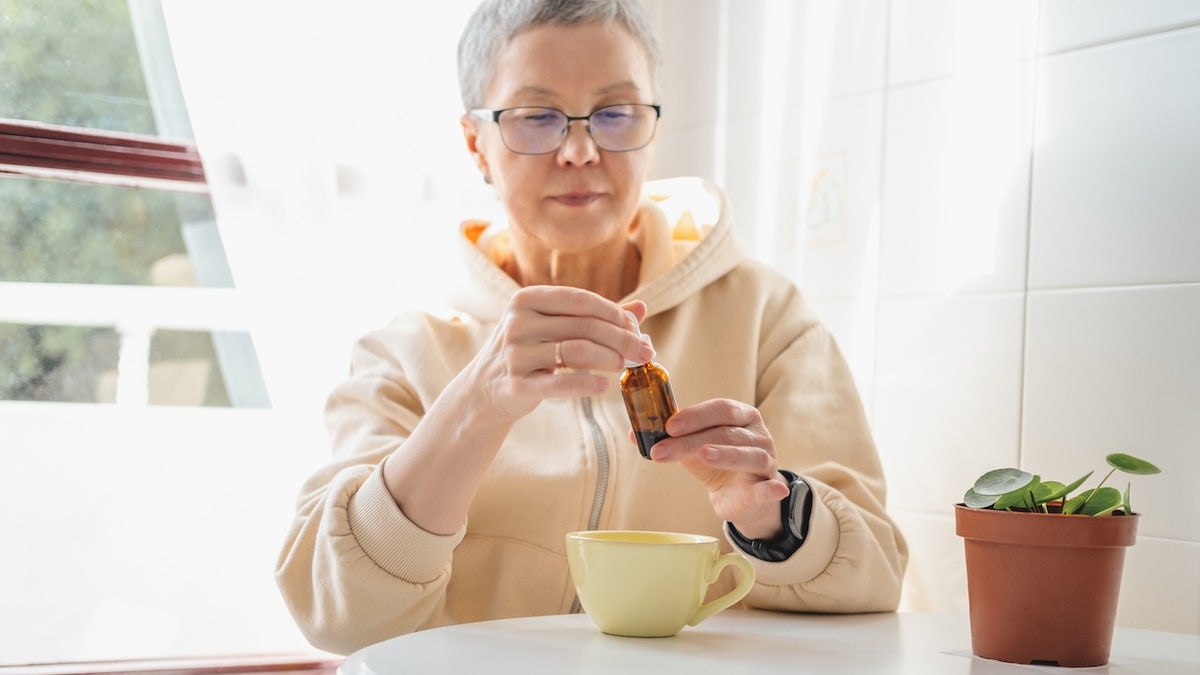 Older woman taking cannabis oil