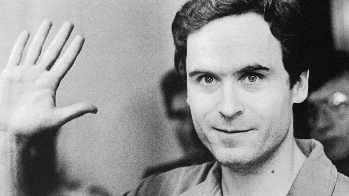 A close-up of Ted Bundy waving his hand.