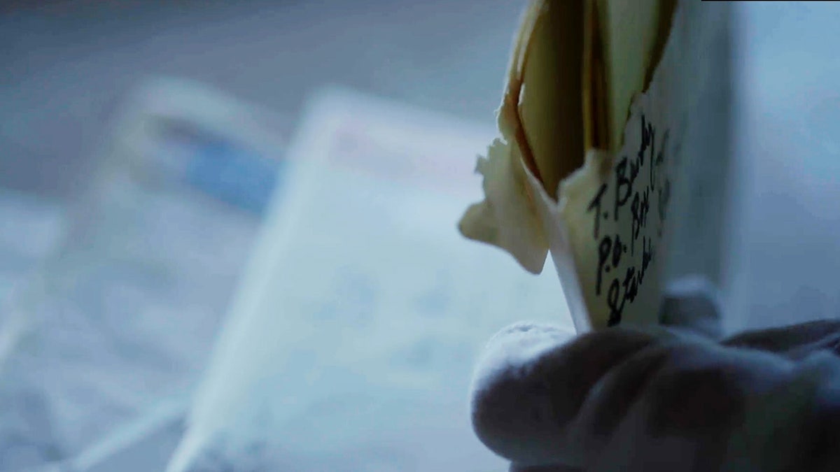 Edna Martin holding letters written by Ted Bundy.