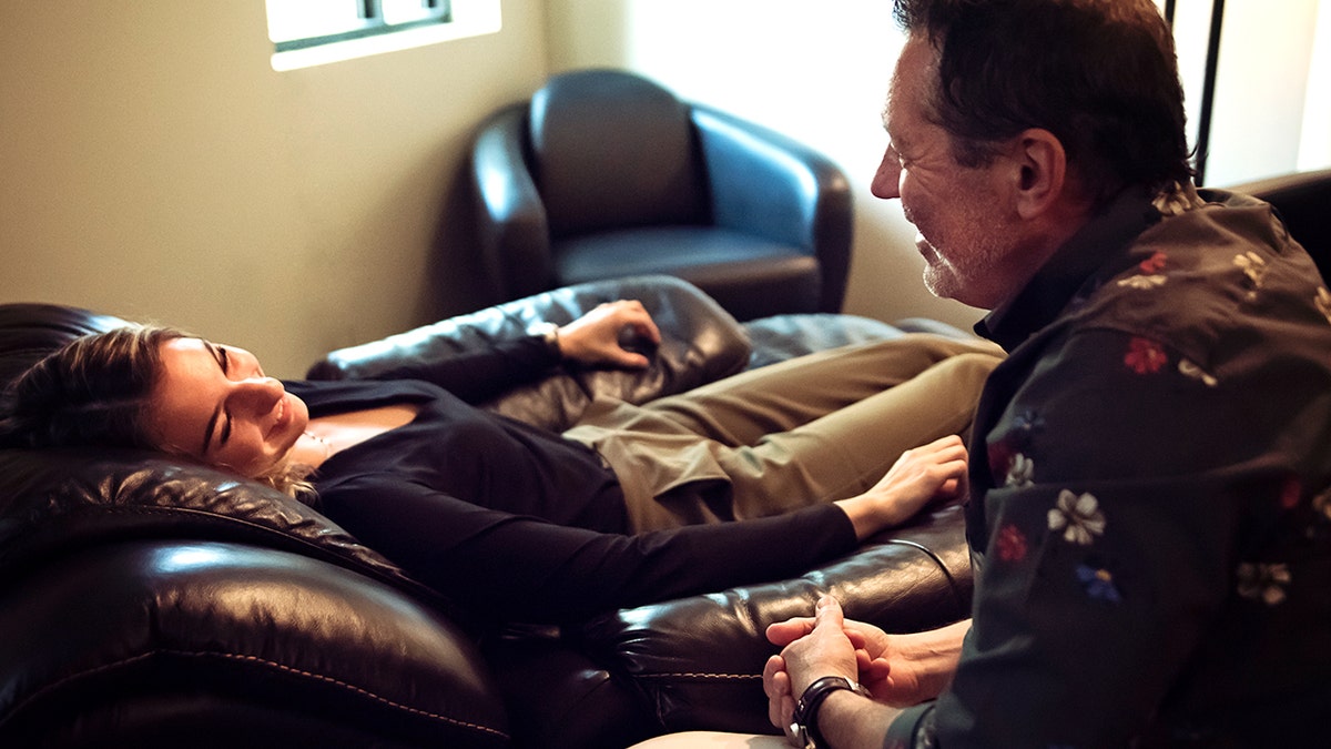 Therapist in session with young woman client. Both are wearing casual clothes.