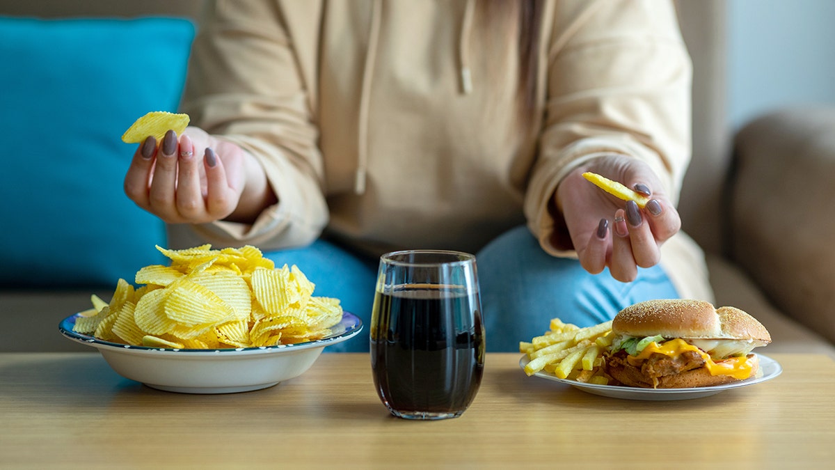Woman sitting down to eat junk food