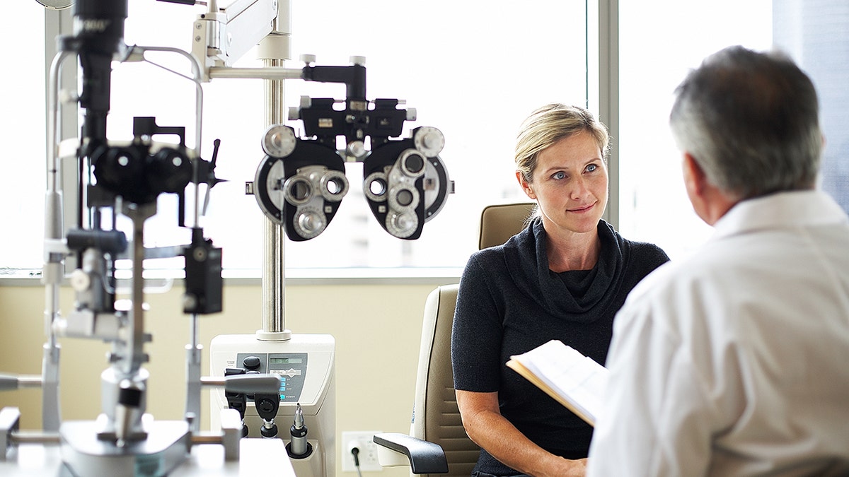 woman sits and listens as eye doctor speaks