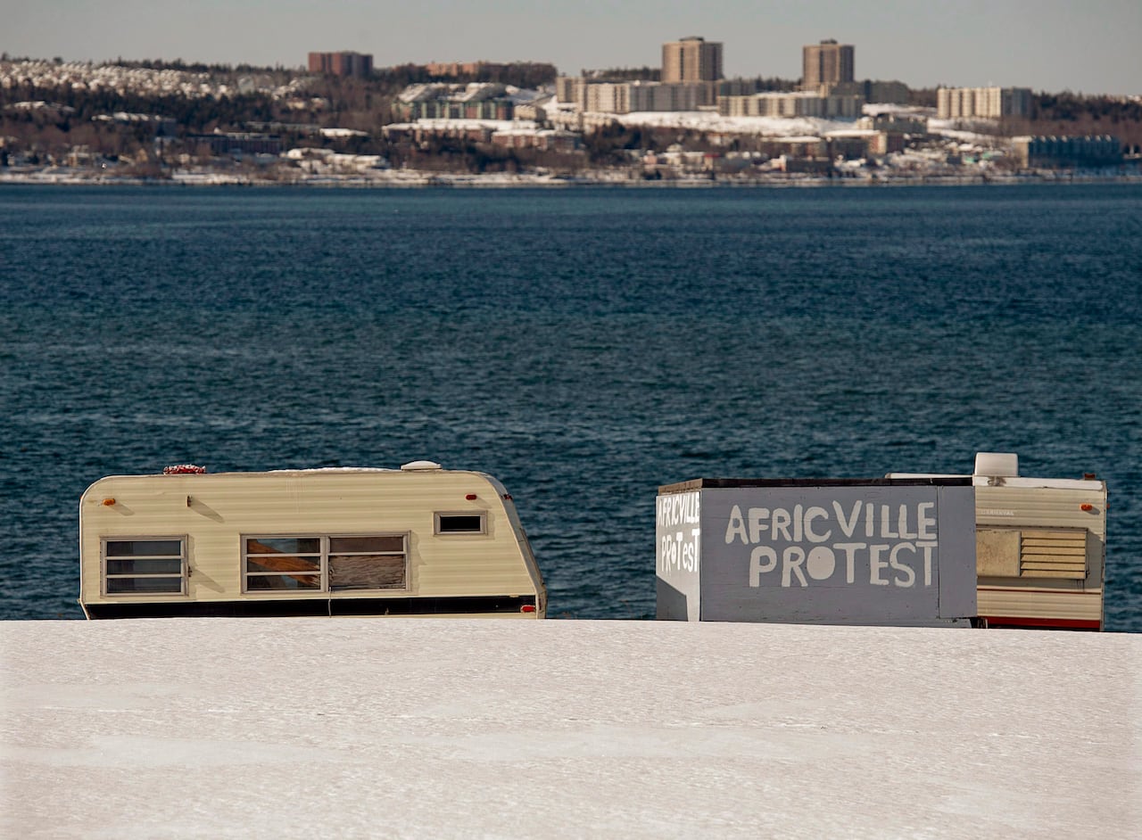 Several trailers sit on a hill in front of the sea