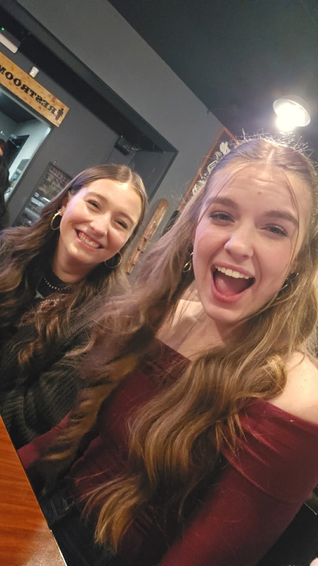 Two women are pictured smiling in what appears to be a restaurant.