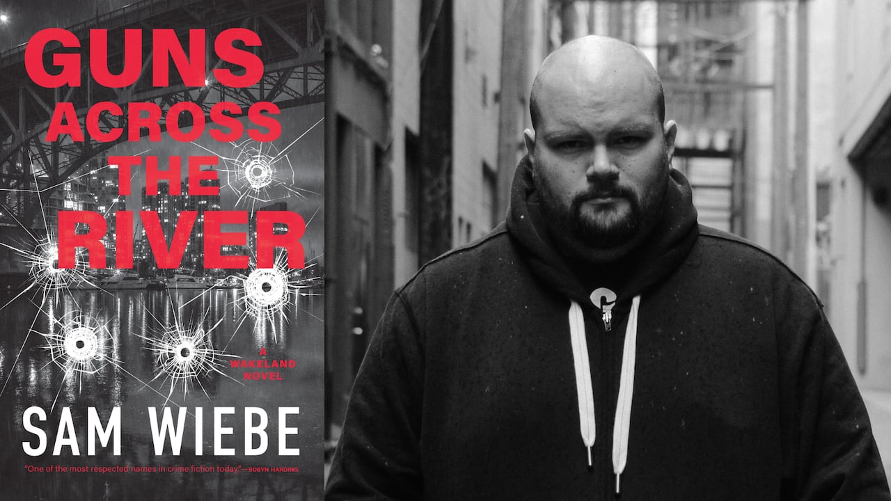 A grey book cover of a window with bullet holes overlooking a river. A black and white headshot of a bald man with a beard wearing a hoodie.