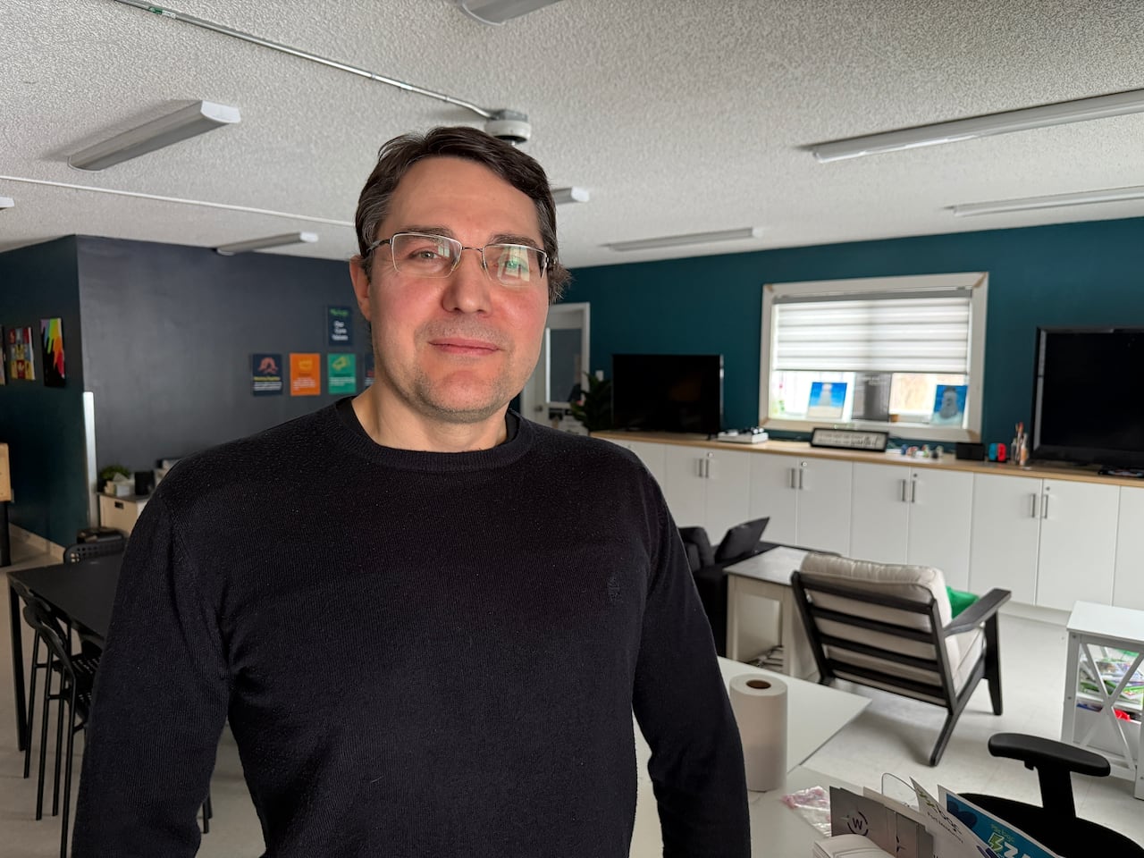 A man stands in a grey room.