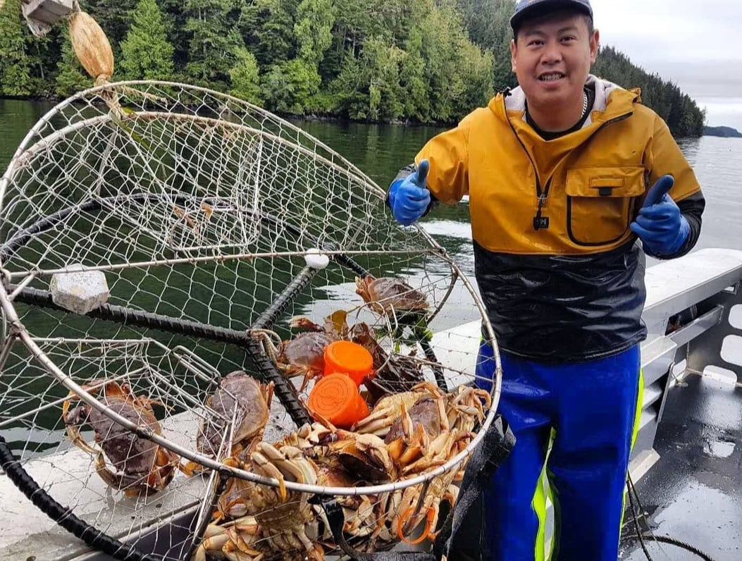 A man gives two thumbs up, standing next to a crap trap.