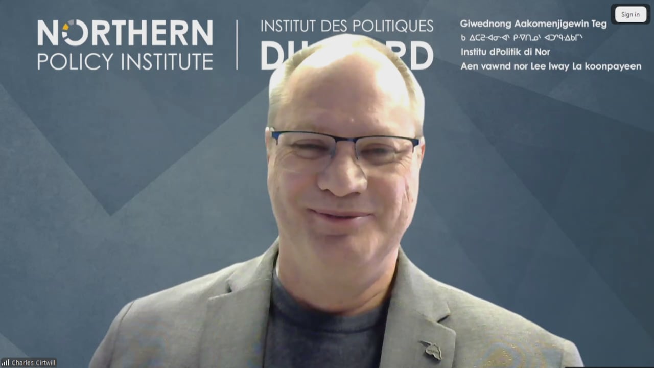 A man with glasses smiles at the camera.