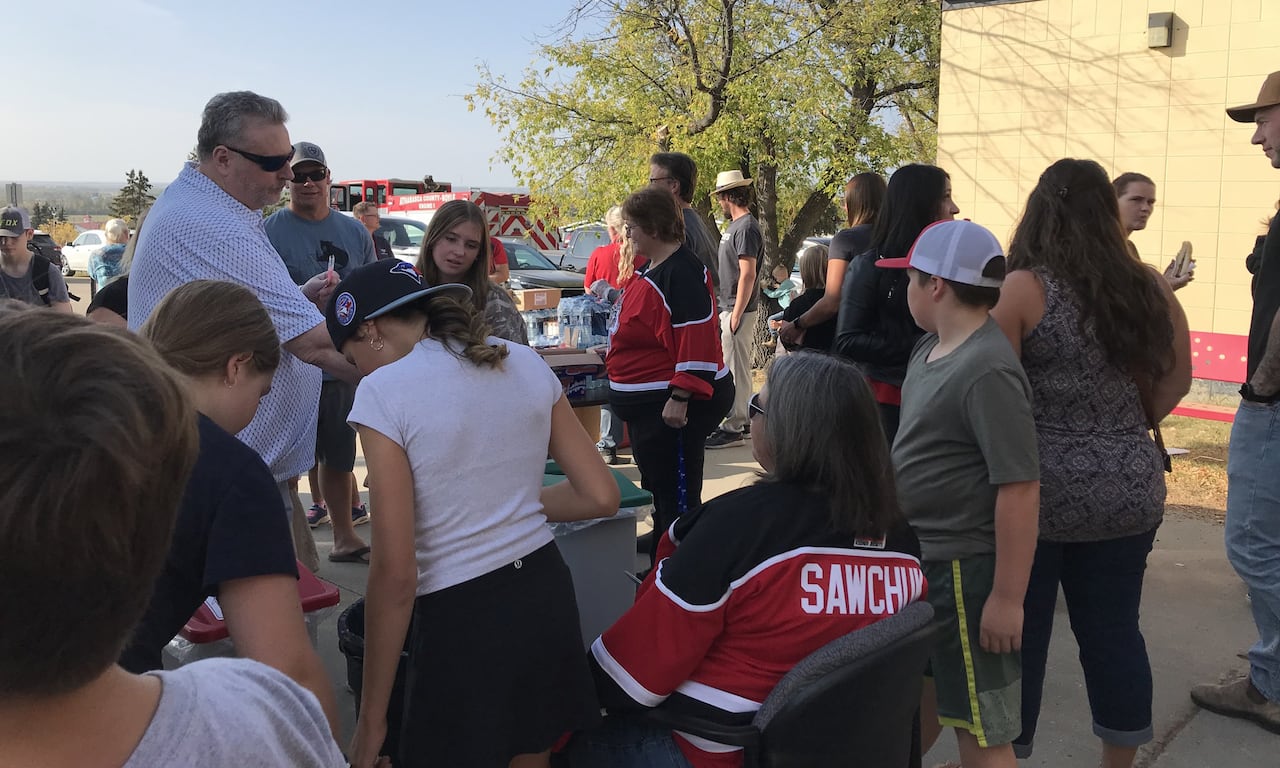 A crowd of people are gathered in a parking lot.