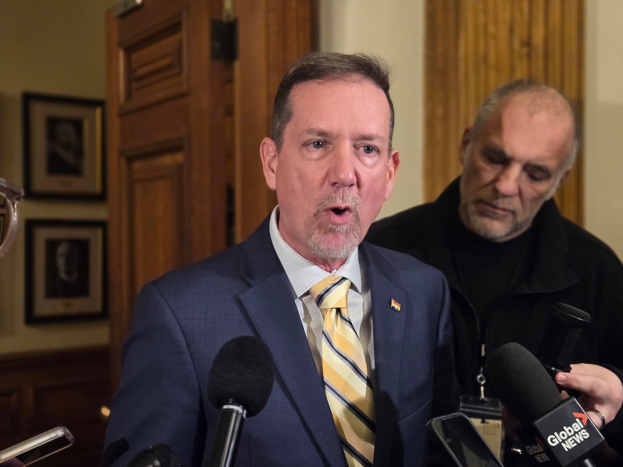 A man speaks into several microphones.