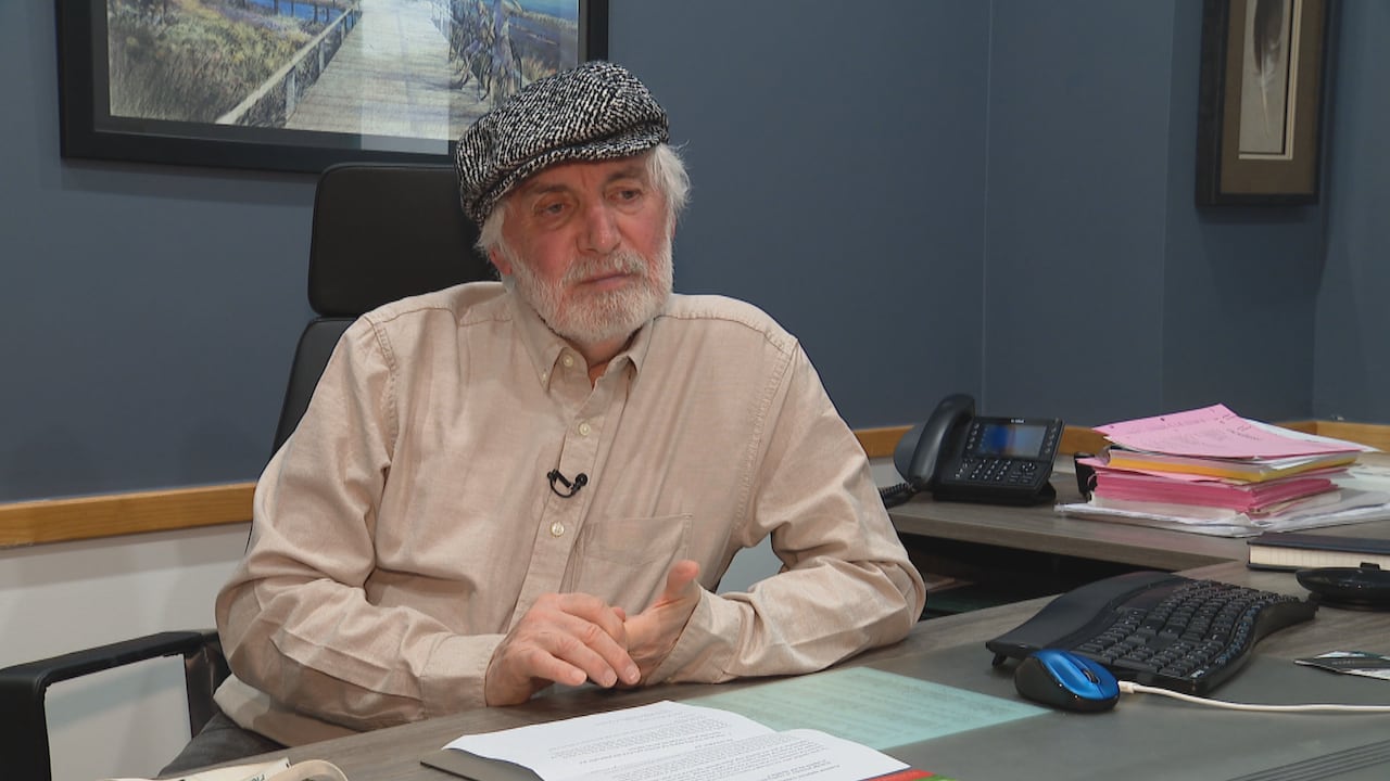 Man in a beige shirt and a black and white knit hat