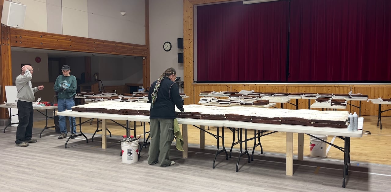 People mill around near a massive series of cakes.
