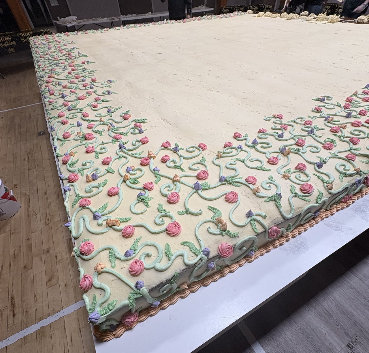 A massive cake with flowers on the icing.