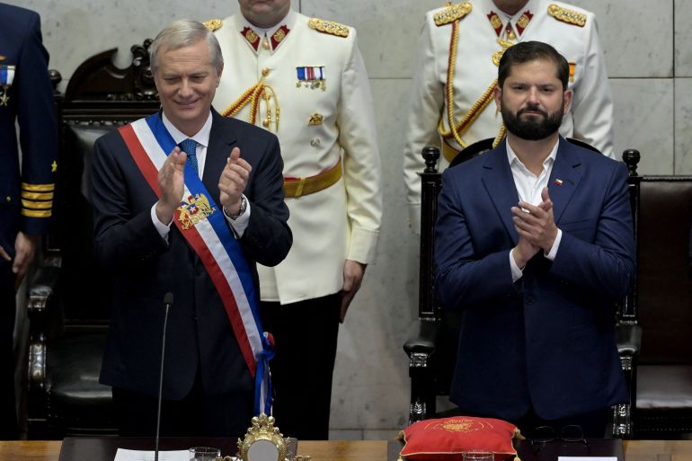 Chile’s new President Jose Antonio Kast (R), wearing the presidential sash, and Chile’s outgoing President Gabriel Boric clap at the National Congress in Valparaiso, Chile, on March 11, 2026.