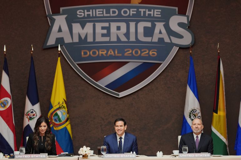 Secretary of State Marco Rubio, center, delivers remarks at a working lunch, flanked by Secretary of Homeland Security Kristi Noem, left, and Commerce Secretary Howard Lutnick, right, at the Shield of the Americas Summit, Saturday, March 7, 2026, at Trump National Doral Miami in Doral, Fla. (AP Photo/Rebecca Blackwell)