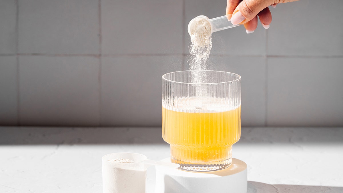 Collagen protein powder in a scoop. Glass of collagen beauty drink. Food supplement.