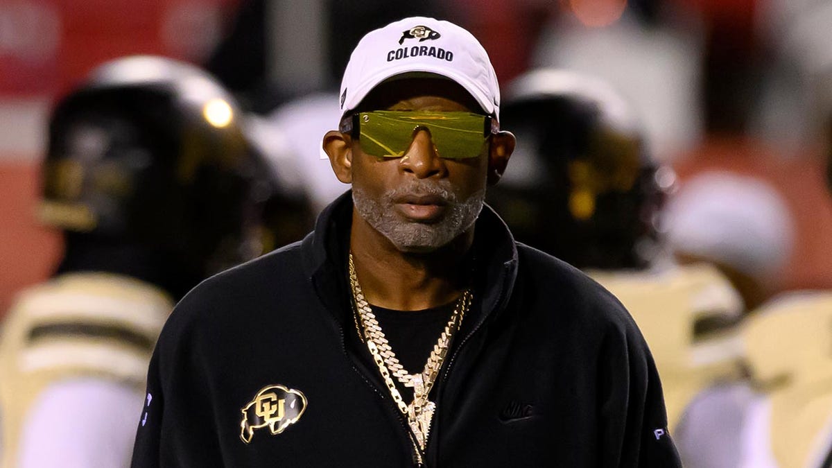 Deion Sanders watches his players warm up