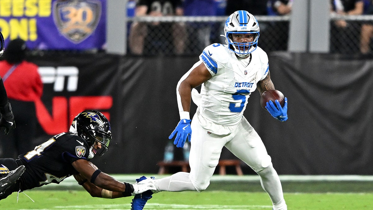 David Montgomery runs with football