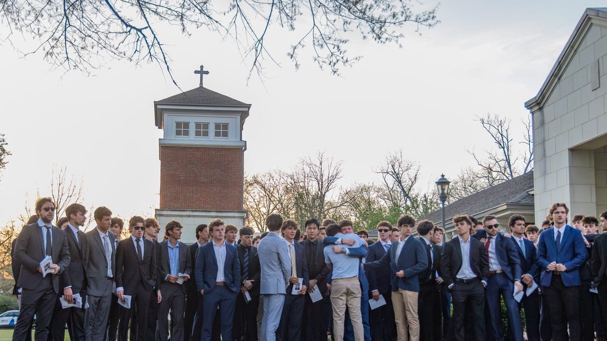 Young men in suits gather outside a university of alabama church