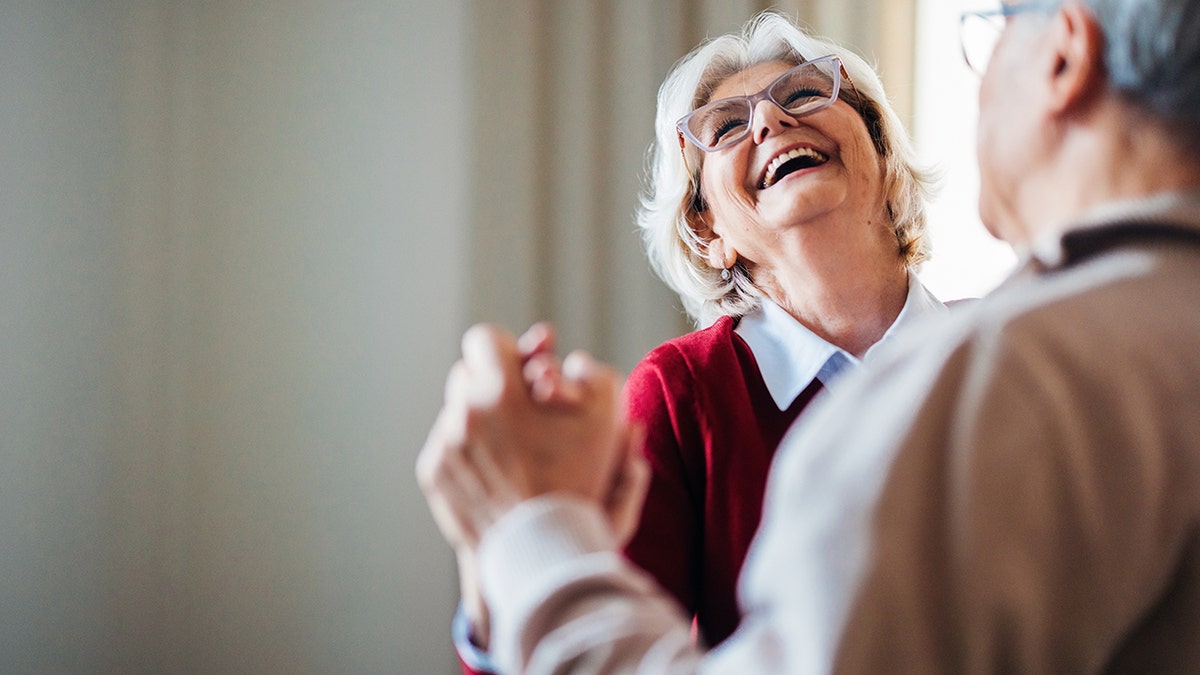 happy senior woman dances with her husband