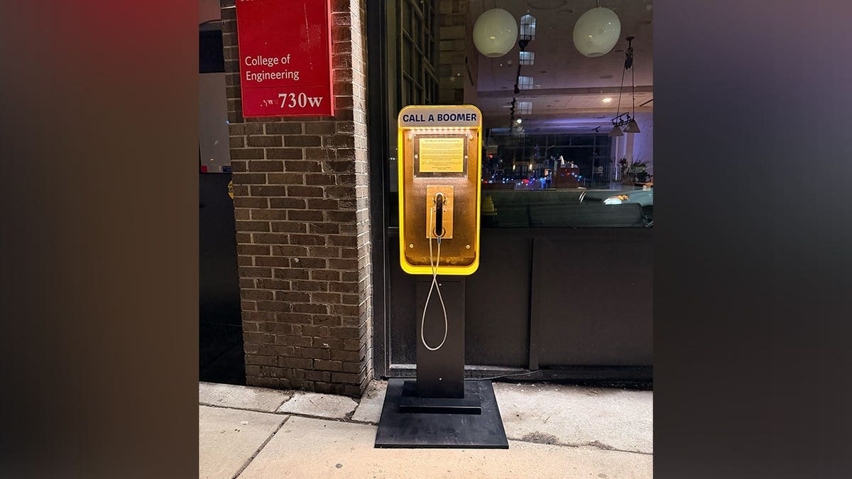 Bright yellow payphone outside Boston coffee shop