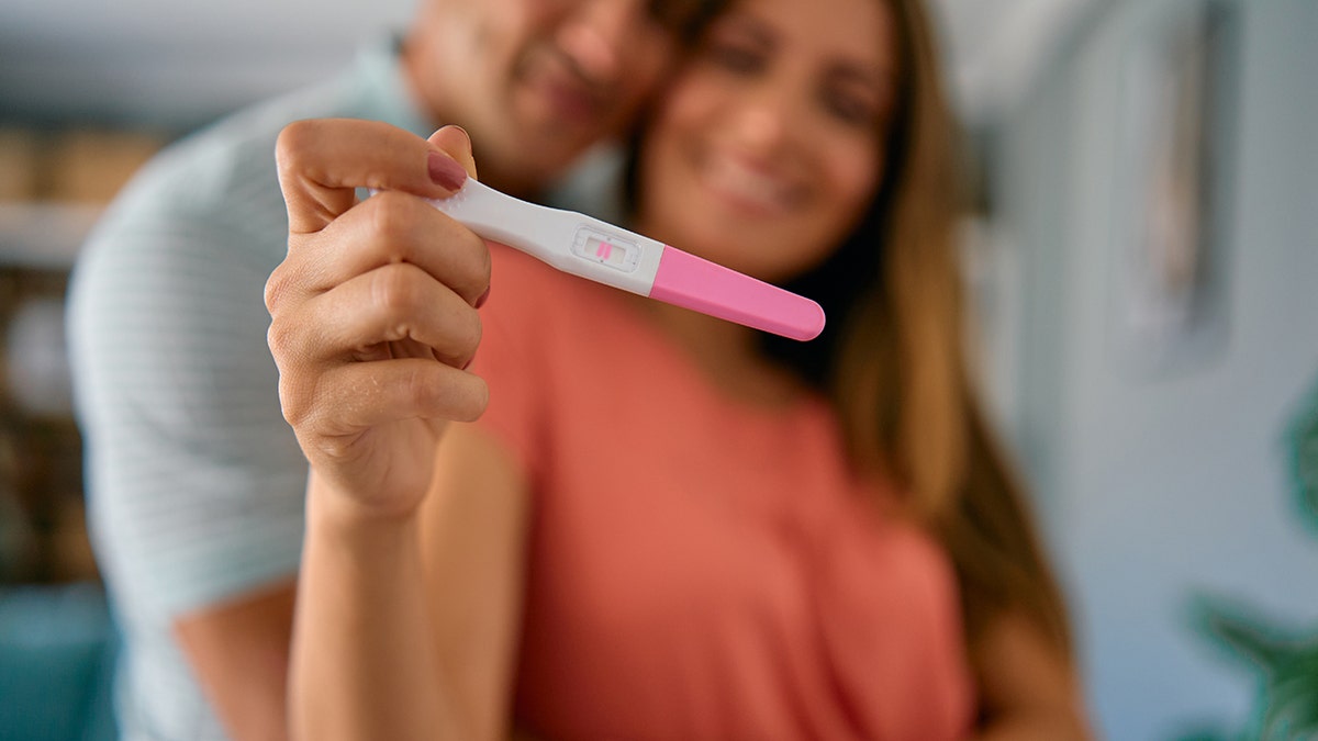 couple holds up pregnancy test