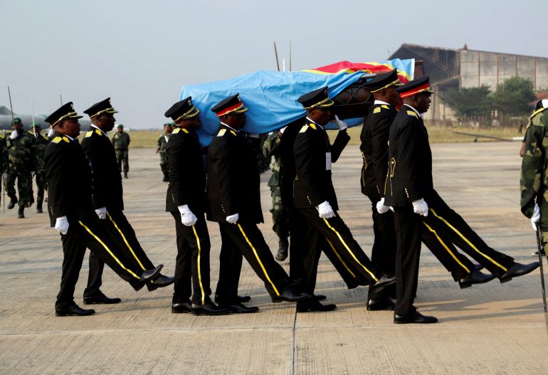 FILE PHOTO: Guards of honour members carry a coffin that contains the only known remains, a tooth of the murdered Congolese independence hero Patrice Lumumba, after he was returned to his family by the Belgian government at Airport in Kinshasa, Democratic Republic of Congo June 27, 2022. REUTERS/Justin Makangara/File Photo