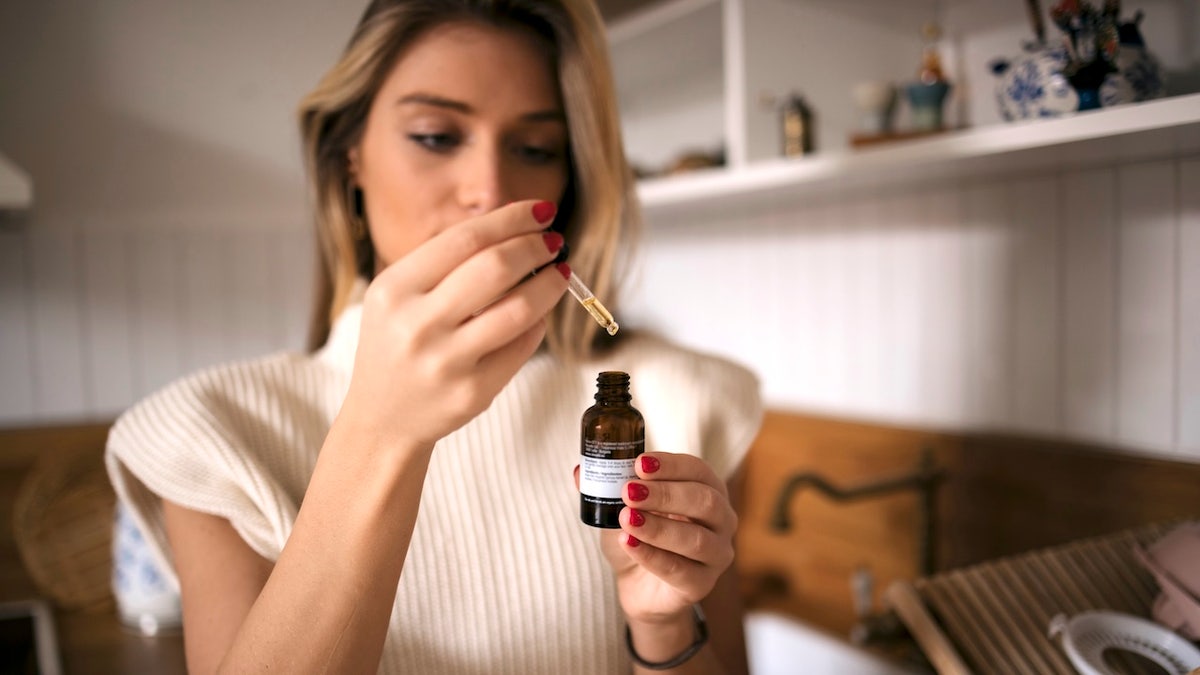 Woman taking cannabis oil drops