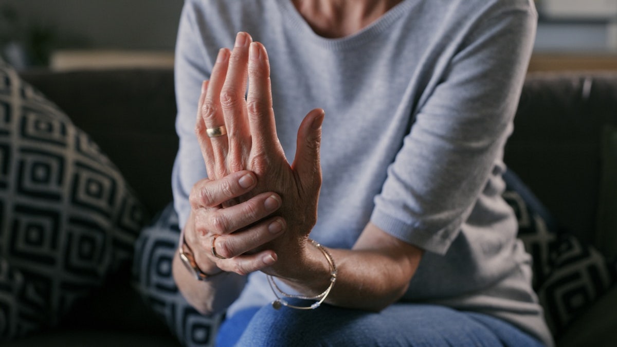 Woman with arthritis, holding hand indicating pain