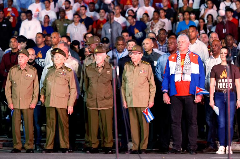 The president of Cuba, Miguel Díaz-Canel (2-R), and his predecessor, Raul Castro (3-R), together with commanders Jose Ramon Machado (L), Guillermo Garcia (2-L) and Ramiro Valdez (3-L), lead the traditional march of the torches to commemorate the 171st anniversary of the birth of the national hero Jose Marti 