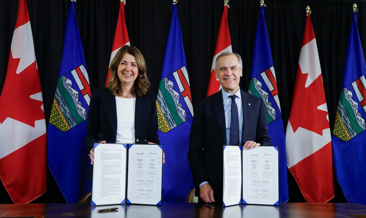 Prime Minister Mark Carney, right, signs an MOU with Alberta Premier Danielle Smith in Calgary, Alta., Thursday, Nov. 27, 2025