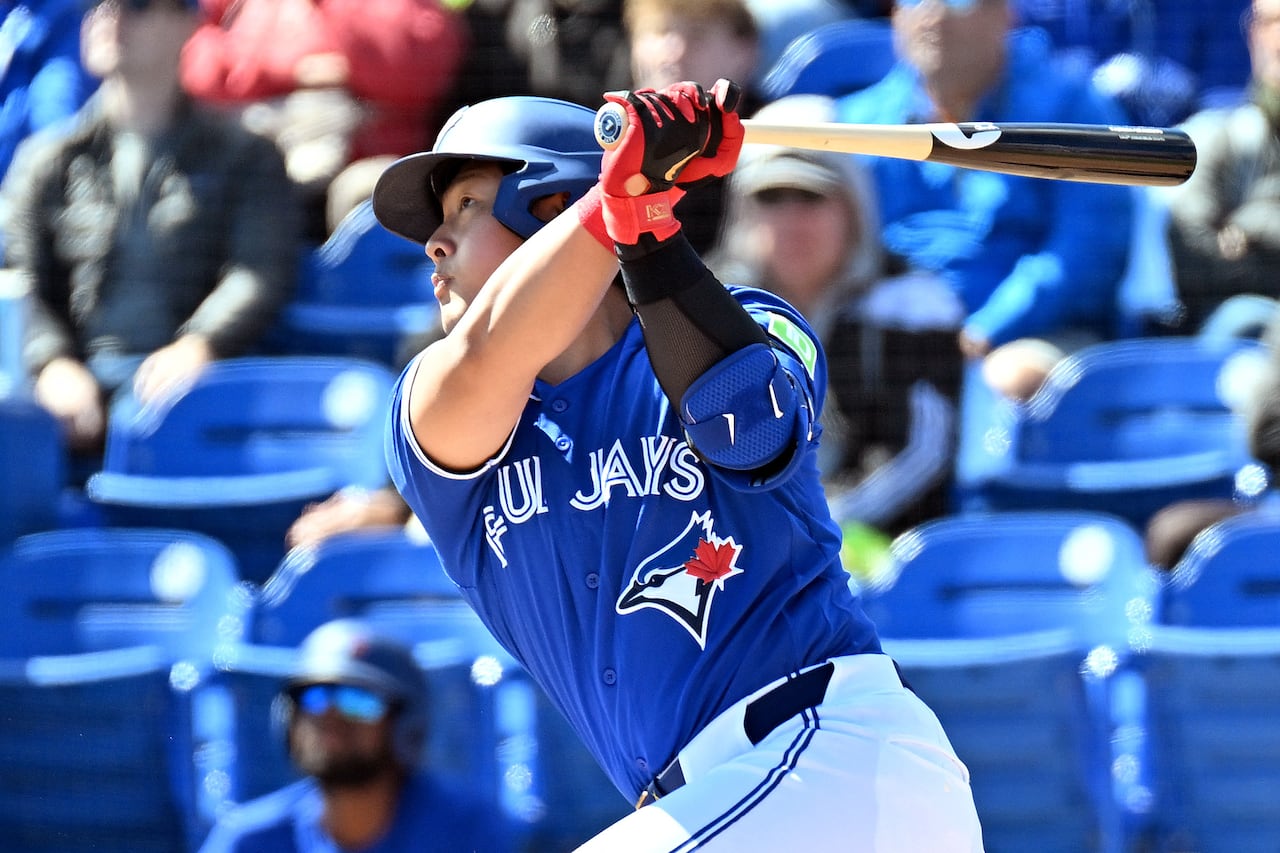 Toronto Blue Jays infielder Kazuma Okamoto finishing a swing on a home-run ball