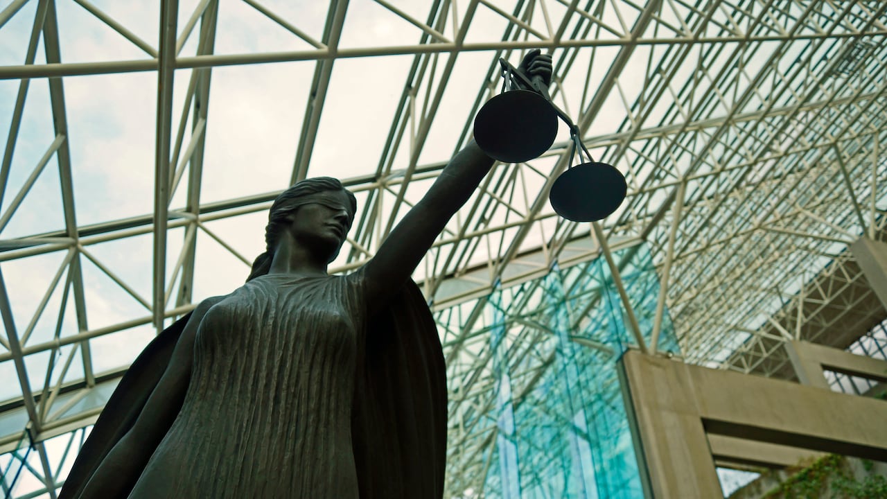 A statue of Lady Justice, blindfolded and holding balanced scales, resides at Vancouver's Supreme Court building. 